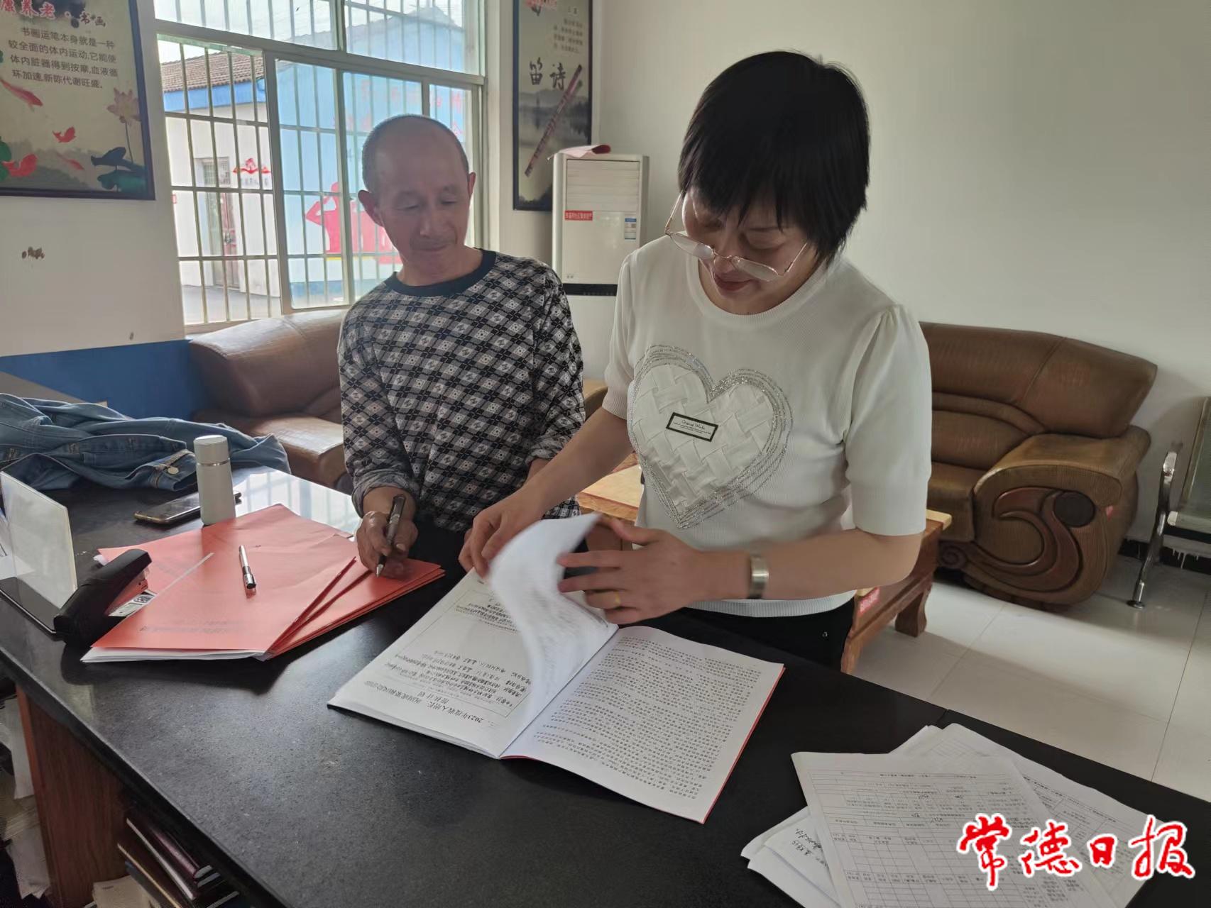 車溪河社區幫扶責任人聶輝珍（右）向聶雙林（左）宣傳他們戶所享受的政策.jpg